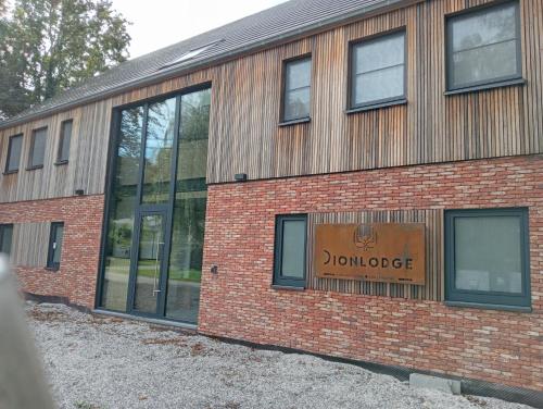 a brick building with a sign that reads jonote at Dionbulles & Dionlodge Guesthouse, Private Wellness pool in option in Chaumont-Gistoux
