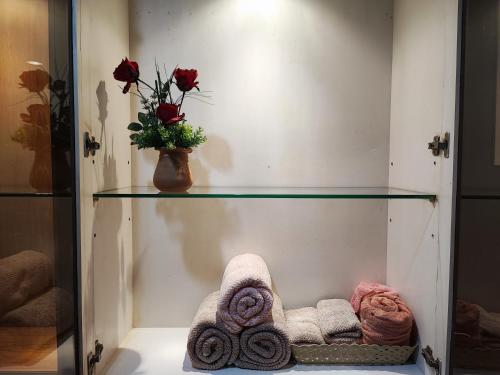 Ban Bang Len的住宿－Rimasehouse 222 ทับ8，一个带毛巾的玻璃架和玫瑰花瓶