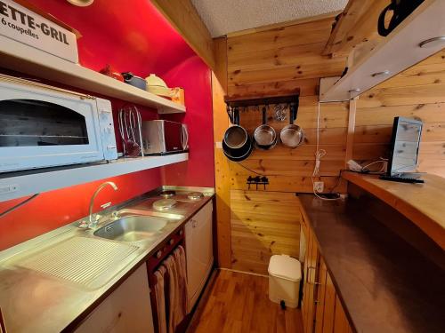 une petite cuisine avec un évier et un micro-ondes dans l'établissement Appartement 2 pièces aux Arcs 1800, 5 pers., au pied des pistes avec balcon, proche commerces et ESF - FR-1-411-31, à Arc 1800