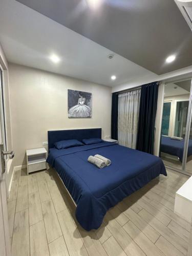 a bedroom with a blue bed with a blue blanket at Seven Seas Condo Pattaya - 7 seas pool view in Jomtien Beach