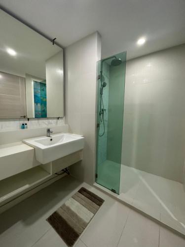 a bathroom with a sink and a glass shower at Seven Seas Condo Pattaya - 7 seas pool view in Jomtien Beach