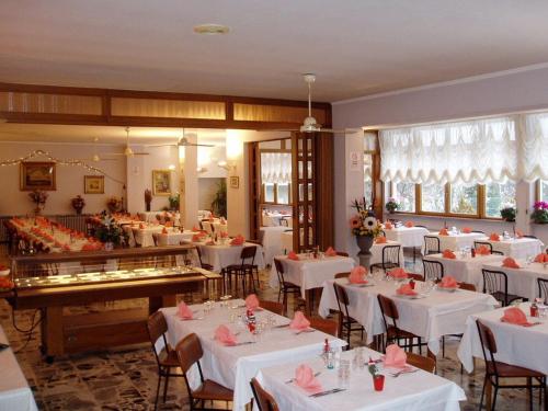 a restaurant with white tables and chairs with pink napkins at Albergo Delle Alpi in Miroglio