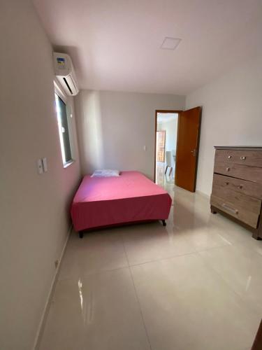 a bedroom with a bed and a dresser in it at Casa Prado Bahia in Prado