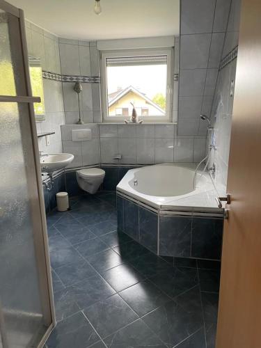 a bathroom with a tub and a toilet and a sink at Ferienwohnung Hellwig in Medebach