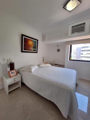 1 dormitorio con 1 cama y TV en la pared en Circuito do Carnaval - Barra Ondina, en Salvador