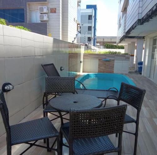 patio z krzesłami i stołem oraz basen w obiekcie Brisa Praiana lll w mieście Cabedelo