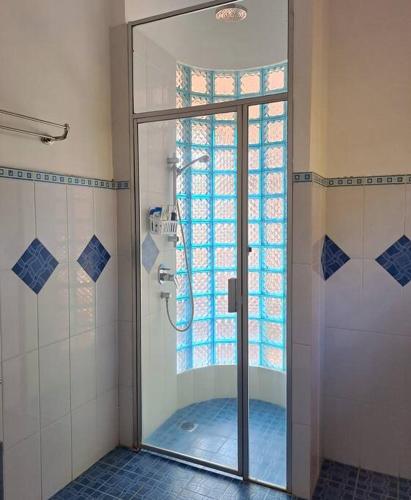 a shower with a glass door in a bathroom at Wonderful Villa Felice in Yogyakarta