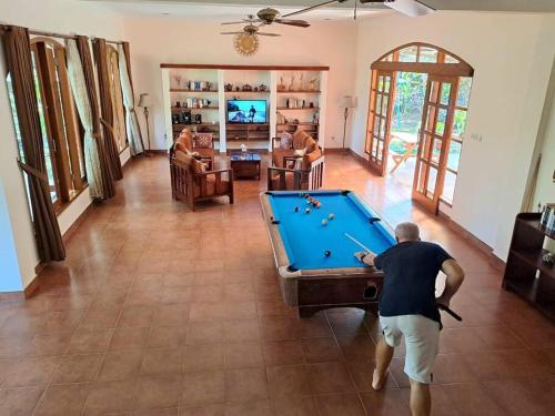 a man playing pool in a living room at Wonderful Villa Felice in Yogyakarta