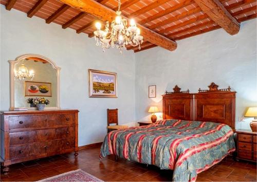 - une chambre avec un grand lit et un lustre dans l'établissement Villa San Ansanino-Piscina privata, à Pari
