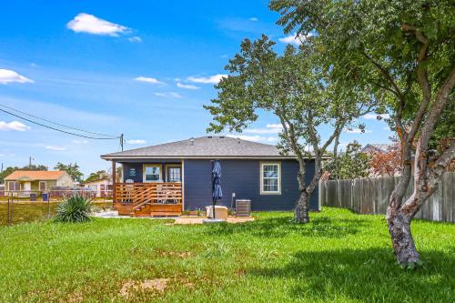 a small blue house in a yard with trees at Ideal Time in Padre Island