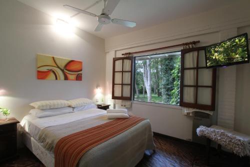 een slaapkamer met een bed en een raam bij Posada del Bosque By HS in Carilo