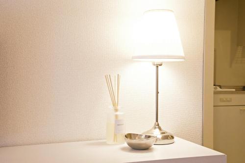 a table with a lamp and a bowl on it at ダイトービル304 in Tokyo