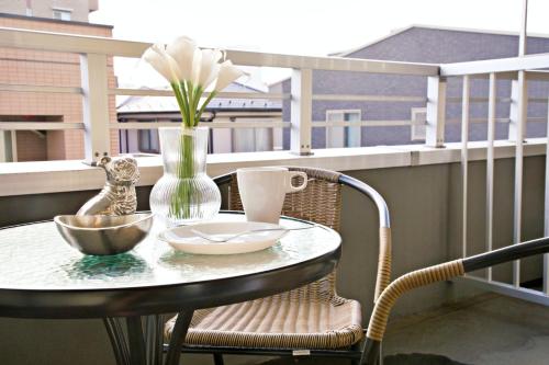 a table and chairs on a balcony with a vase at ダイトービル304 in Tokyo