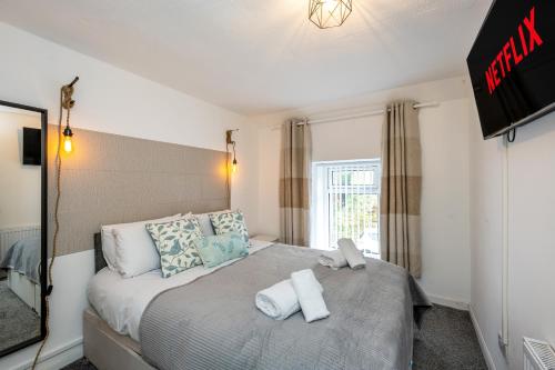 a bedroom with a bed with two towels on it at The New Lodge - Cottage - Tv in every bedroom! in Pontardawe