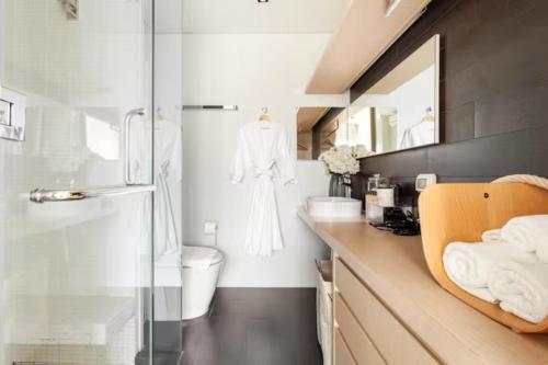 een badkamer met een wastafel, een toilet en een spiegel bij Family Suite Sea view 2Bedroom at Veranda Residence Pattaya in Na Jomtien