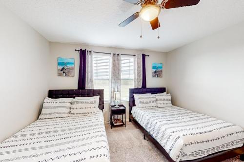 um quarto com 2 camas e uma ventoinha de tecto em Pelican Escape em Davenport
