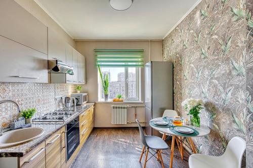 a kitchen with a table and chairs and a sink at Green Boutique - квартира в изумрудных оттенках на Мынбаева in Almaty