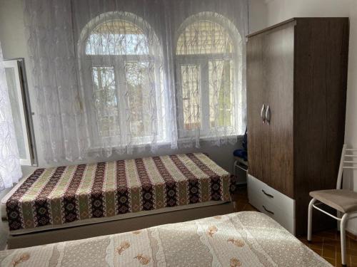 a bedroom with two beds and a dresser and two windows at Side home beach in Side