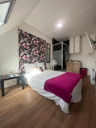 ein Schlafzimmer mit einem großen Bett mit einer lila Decke in der Unterkunft Petit studette sous le toit in the heart of the fashion and luxury district in Paris