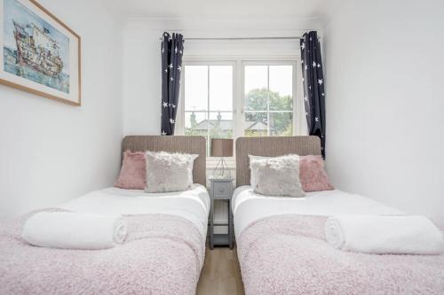 twee bedden in een kamer met een raam bij Stylish 3 Bed Sunningdale Center - Parking - Call 4 LONG STAY discount in Sunningdale