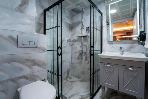 y baño con ducha, aseo y lavamanos. en Rubby Hotel Kadıköy en Estambul