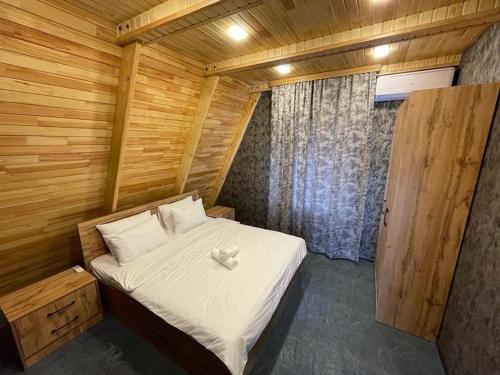 a bedroom with a bed in a wooden room at Qafqaz Eminent Chalet in Gabala
