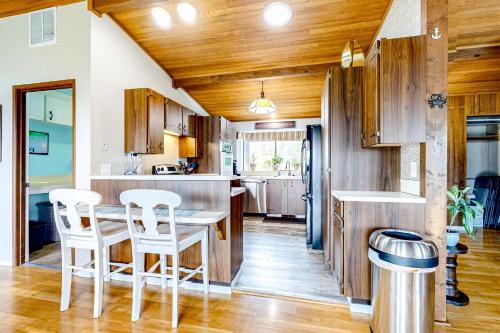 a kitchen with wooden cabinets and a table and chairs at Resting Eagle Beach House in Bremerton