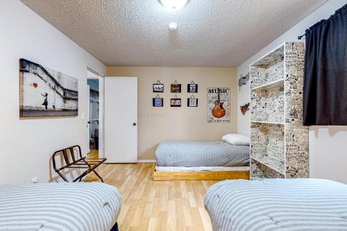 Un dormitorio con 2 camas y una pared con cuadros. en Resting Eagle Beach House, en Bremerton