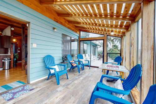 a patio with blue chairs and tables on a blue house at Resting Eagle Beach House in Bremerton