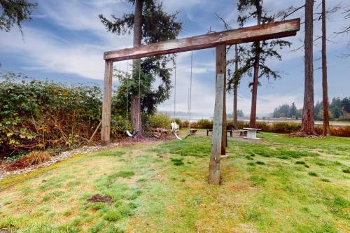 a wooden swing in a grassy field at Resting Eagle Beach House in Bremerton