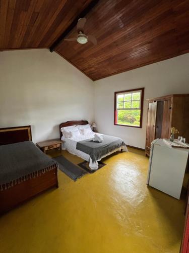 a room with two beds in a room with water at Fazenda do Engenho in Santa Rita do Rio Abaixo