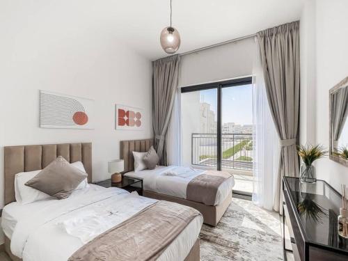 1 Schlafzimmer mit 2 Betten und einem großen Fenster in der Unterkunft StoneTree - 3 BR with 1 Maids Room Villa in Camelia - Arabian Ranches in Dubai