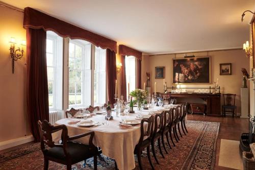 a long dining room with a long table and chairs at Blyth Hall in Coleshill