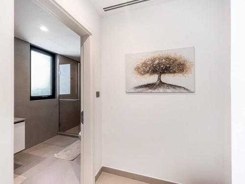 einen Flur mit einem Bild eines Baumes an der Wand in der Unterkunft StoneTree - 3 BR with 1 Maids Room Villa in Camelia - Arabian Ranches in Dubai