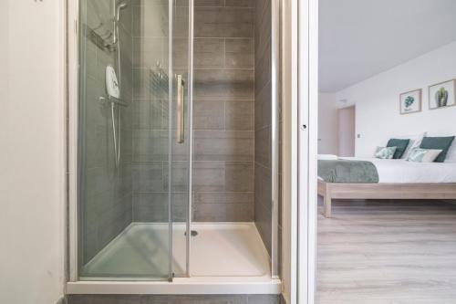 a shower with a glass door in a bedroom at Maison familiale 12 min Disneyland in Quincy-Voisins