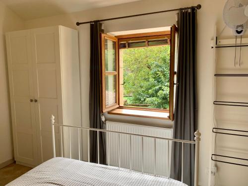 a bedroom with a bed and a window at Le Gîte du Pont de Cause in Saint-Cybranet