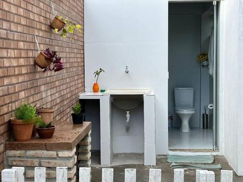 La salle de bains est pourvue d'un lavabo et de toilettes. dans l'établissement Chácara Sombra da Mangueira - 150 Mts da Praia, à Itaparica Town