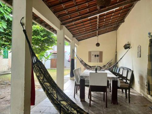 - une salle à manger avec une table et des chaises dans l'établissement Chácara Sombra da Mangueira - 150 Mts da Praia, à Itaparica Town