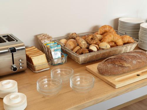 a table with bread and a tray of loaves of bread at Hotel St. Josef in Zürich
