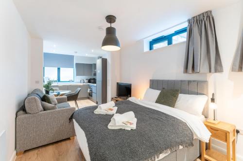 a bedroom with a bed and a couch and a living room at 123 Queen Street - Home Crowd Luxury Apartments in Sheffield