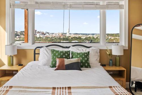 ein Schlafzimmer mit einem Bett mit Kissen und einem Fenster in der Unterkunft City Skyline - Outside decks - Contemporary in Pittsburgh