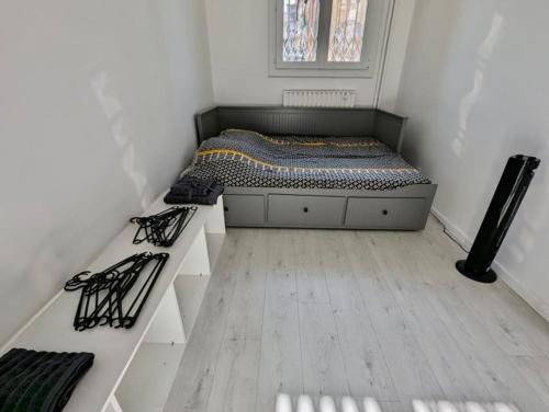- une petite chambre avec un lit et du parquet dans l'établissement Magnifique T2 refait à neuf - Calme & Tout Equipé avec Parking, à Grenoble