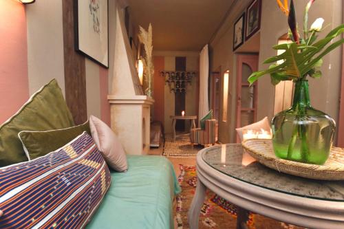 Riad 117 في مراكش: غرفة معيشة بها مزهرية على طاولة وأريكة