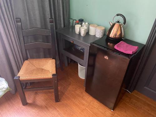 a table with a tea kettle and a chair in a room at Mountain Suite, Stunning Views, Brecon Beacons in Llanhamlach
