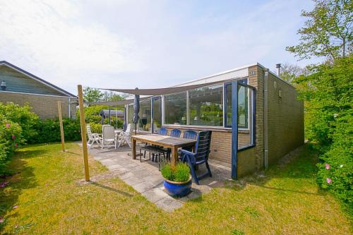una casa con tavolo e sedie in cortile di Garnekuul 84 - car free park - Callantsoog a Callantsoog
