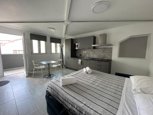 a bedroom with a bed and a table and a kitchen at Corridoni33 - Immobili e Soluzioni Rent in Bergamo