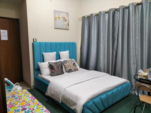 - une chambre avec un lit bleu et des oreillers dans l'établissement BNB Furnished Residential Studio apartment, à Dubaï