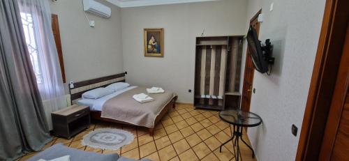 a small room with a bed and a television at Hotel Villa in Kutaisi