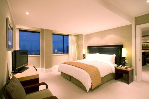 a hotel room with a bed and a television at Southern Sun Cape Sun in Cape Town