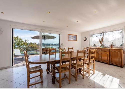 une cuisine et une salle à manger avec une table et des chaises dans l'établissement Locqui, à Locquirec
